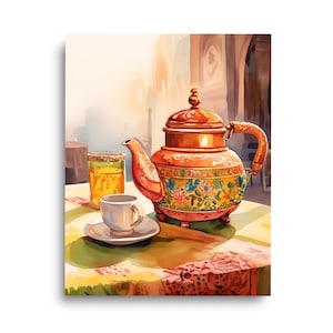 May include: A copper-toned teapot with a floral pattern around the base, featuring a curved handle and a lid. Next to the teapot sits a small white teacup on a matching saucer and a tall glass filled with a golden liquid, all on a patterned cloth.