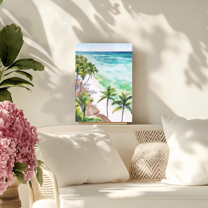 Puede incluir: Pintura a la acuarela de una escena de playa tropical. La obra de arte representa una playa de arena blanca, agua turquesa y exuberantes palmeras verdes. El cielo es de color azul claro. La pintura se exhibe sobre una superficie blanca.