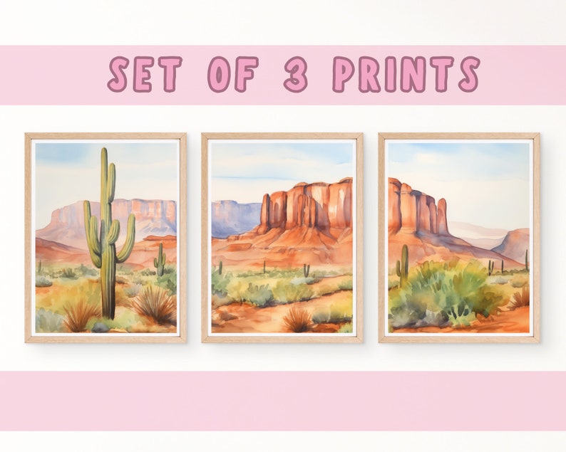 May include: A set of three framed watercolour prints featuring desert landscapes with saguaro cacti, red rock formations, and sparse vegetation under a pale blue sky. The text SET OF 3 PRINTS is displayed in pink letters above the framed artwork.