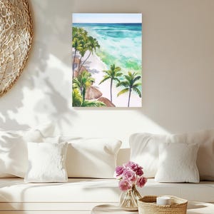 Puede incluir: Pintura a la acuarela de una escena de playa tropical. La obra de arte representa una playa de arena blanca, agua turquesa y palmeras. El cielo es de un azul claro. La pintura se exhibe en una pared blanca sobre un sof&aacute; blanco.