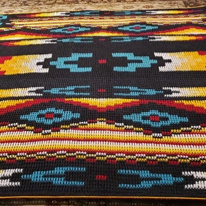 May include: A black and white crochet blanket with geometric patterns in red, yellow, and turquoise.