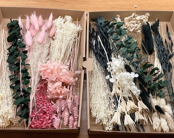 Puede incluir: Dos cajas llenas de flores y follaje secos. La caja de la izquierda contiene flores secas rosas y blancas, incluyendo hierba de la pampa, eucalipto y aliento de bebé. La caja de la derecha contiene flores secas blancas y negras, incluyendo hierba de la pampa, eucalipto y hierbas secas.