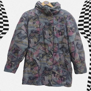 May include: A vintage patterned jacket in shades of blue, pink, and green. The jacket has a high collar, button closures, and a unique geometric design. The jacket is hanging on a wooden hanger.