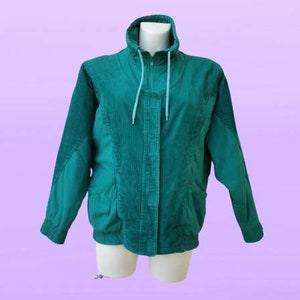 Pode incluir: Uma jaqueta de veludo cotelê verde com fecho de zíper e capuz com cordão de ajuste azul claro.