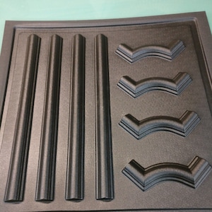 May include: A black silicone mold with four rectangular and four curved shapes. The mold is designed for creating decorative elements for crafts.