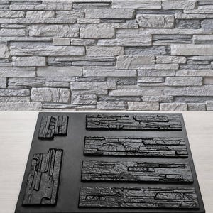Puede incluir: Un molde de silicona negro rectangular con seis cavidades distintas diseñadas para crear texturas de piedra. El molde incluye dos formas rectangulares verticales a la izquierda y cuatro formas rectangulares horizontales a la derecha.