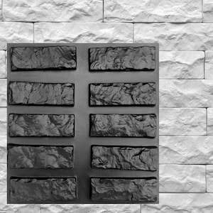 May include: A black silicone mold with 10 rectangular cavities, each with a textured design resembling a stone brick. The mold is used for creating decorative concrete or resin projects.