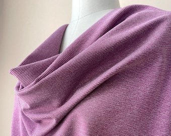 May include: A close-up of a purple ribbed fabric with a subtle sheen. The fabric is draped over a form and has a soft, textured appearance.
