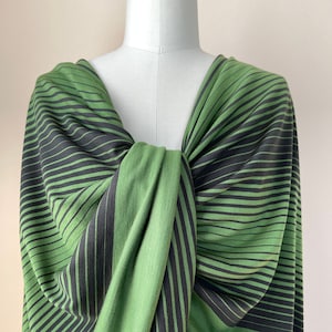 May include: A green and black striped fabric draped over a dress form. The fabric is soft and has a subtle sheen.