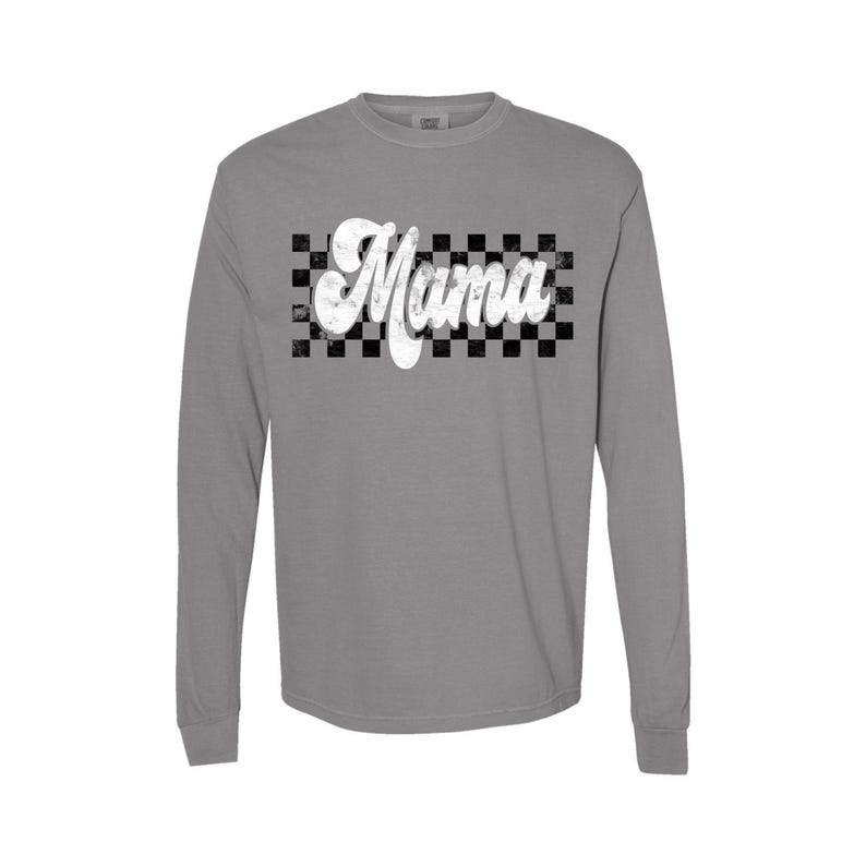 Puede incluir: Una camiseta gris de manga larga con un patr&oacute;n de cuadros blancos y la palabra "Mama" en una fuente retro.