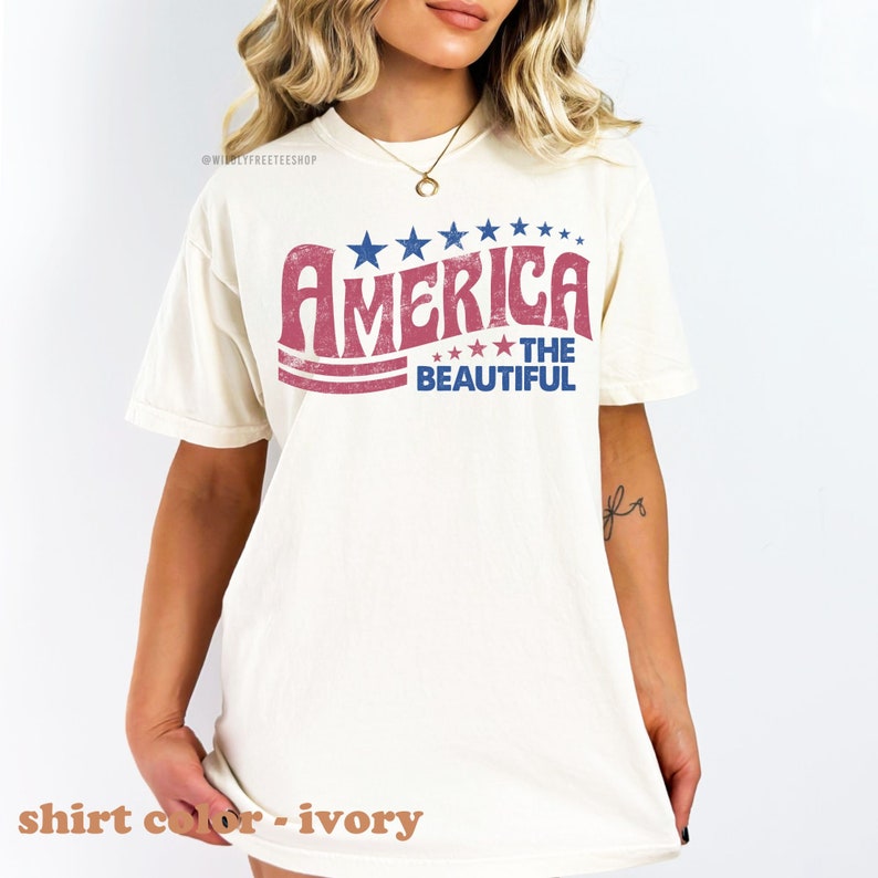 Pu&ograve; includere: Una t-shirt bianca con una grafica in stile vintage che dice "America The Beautiful" in lettere rosse e blu con stelle. La t-shirt &egrave; realizzata in un materiale morbido e confortevole e ha una vestibilit&agrave; rilassata.
