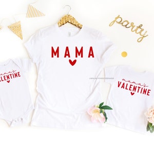 May include: White t-shirts with red text and hearts. The larger shirt says "MAMA" and the smaller shirt says "mama's VALENTINE".