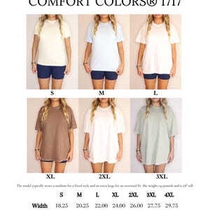 May include: Size chart for Comfort Colors 1717 t-shirts. The image shows models wearing various shirt sizes, from S to 3XL, in different colors. Measurements are provided for width, length, and sleeve length in inches. The model is 5'8" and weighs 145 pounds.