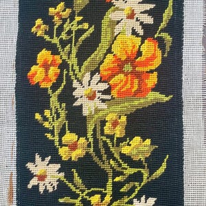 May include: Needlepoint floral design on black canvas. The artwork features yellow, orange, and white flowers with green stems and leaves. The canvas is rectangular, with the text "Collection S.E.G. de Paris" at the top and "Made in France" on the left side.