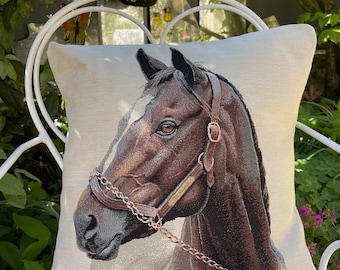 Può includere: Cuscino quadrato decorativo con un arazzo dettagliato di una testa di cavallo marrone con una macchia bianca. Il cavallo indossa una cavezza con una catena d'oro. Il cuscino è su una sedia di metallo bianco.