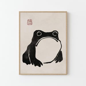 May include: Black and white illustration of a frog with a large, round belly. The frog is facing forward with its mouth closed. The illustration is on a beige background with a red stamp in the top left corner.