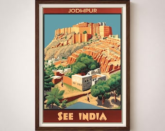 May include: A framed vintage travel poster for Jodhpur, India, featuring a detailed illustration of a large, orange-red fort atop a rocky hill. The poster has a blue sky background and the text "SEE INDIA" at the bottom.
