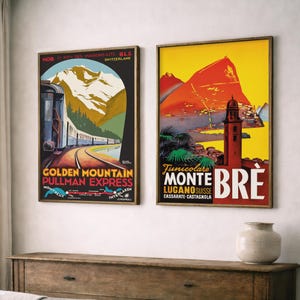 Op de afbeelding: Twee ingelijste vintage reisposters. De linkerposter toont een trein op een spoor met bergen en de tekst "Golden Mountain Pullman Express". De rechterposter toont een berg en een toren met de tekst "Monte Bre".