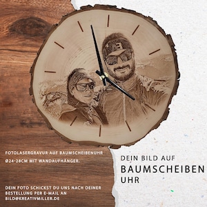 Könnte beinhalten: Eine Holzuhr mit einem Foto eines Paares, das auf das Zifferblatt graviert ist. Die Uhr hat einen Durchmesser von 24-28 cm und wird mit einem Wandaufhänger geliefert. Der Text "DEIN BILD AUF BAUMSCHEIBEN UHR" ist unter der Uhr gedruckt.