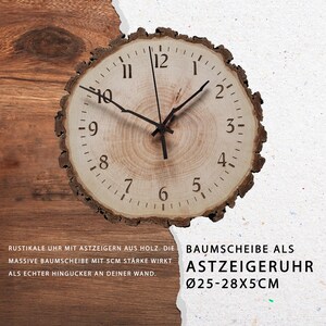 May include: A rustic wooden clock with black hands and Roman numeral markings. The clock is made from a tree slice with a natural bark edge. The text "BAUMSCHEIBE ALS ASTZEIGERUHR &Oslash;25-28X5CM" is printed below the clock.