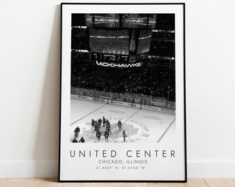 May include: Black and white photograph of a hockey game at the United Center in Chicago, Illinois. The scoreboard displays "BLACKHAWKS" and the score. The players are on the ice, and the crowd is in the stands.