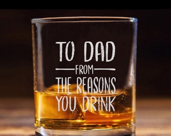 Puede incluir: Un vaso de rocas de vidrio transparente con el texto "To Dad - From The Reasons You Drink" grabado en el lateral. El vaso está lleno de líquido ámbar y cubitos de hielo.