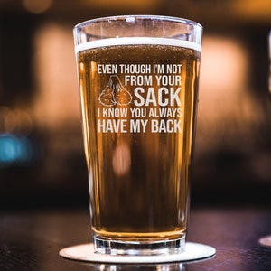 May include: A clear glass beer mug with a humorous saying: "Even though I'm not from your sack I know you always have my back".