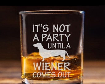 May include: A clear glass shot glass with the text "It's not a party until a wiener comes out" and a silhouette of a dachshund dog.