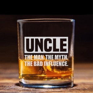 May include: A clear glass with a black and white design that reads "UNCLE THE MAN. THE MYTH. THE BAD INFLUENCE." The glass is filled with amber liquid and ice cubes.