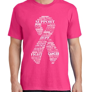 May include: Pink t-shirt with a white design featuring the words "Support", "Hope", "Fight", "Survivor", "Cure", "Joy", and other words related to breast cancer awareness.