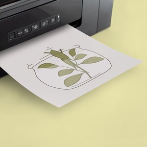 May include: A black and white line drawing of a plant with leaves inside a clear jar, printed on a white sheet of paper coming out of a black printer.