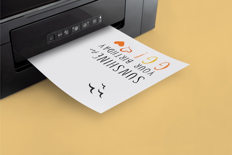 May include: A white card with the text "SUNSHINE your birthday 6!" printed on it is being printed from a black printer. The card has two red hearts and a rainbow-colored "6" on it.