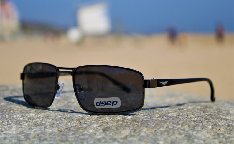 May include: Black rectangular sunglasses with a silver logo that says "deep" on the right lens.