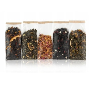 May include: Five clear plastic pouches filled with different types of loose leaf tea. The pouches are lined up horizontally and have a brown paper label at the top.