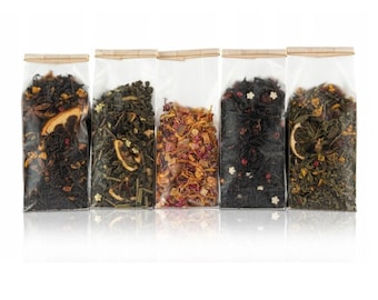 May include: Five clear plastic pouches filled with different types of loose leaf tea. The pouches are lined up horizontally and have a brown paper label at the top.