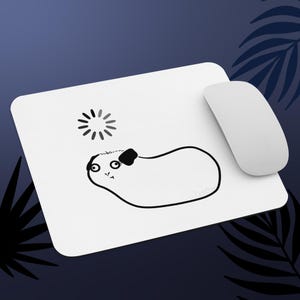 May include: White mousepad with a black and white guinea pig illustration and a white computer mouse. The guinea pig design includes a sun graphic. The mousepad is rectangular with rounded corners.