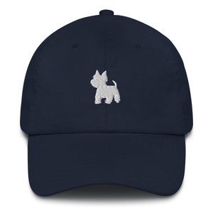 Peut inclure: Une casquette de baseball bleu marine avec une silhouette brodée blanche d'un petit chien.