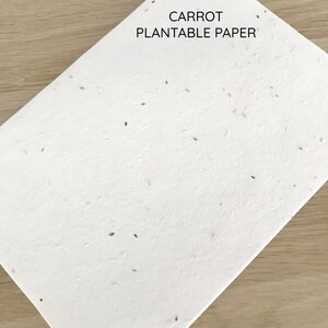 以下が含まれることがあります： 黒い文字で「CARROT PLANTABLE PAPER」と印刷された白い植栽可能な紙です。