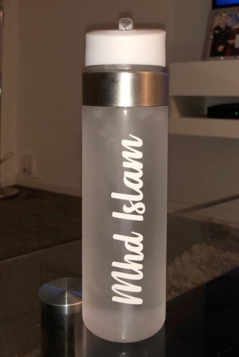 May include: A frosted white water bottle with a silver lid and a white sticker that says "Mhd Islam".