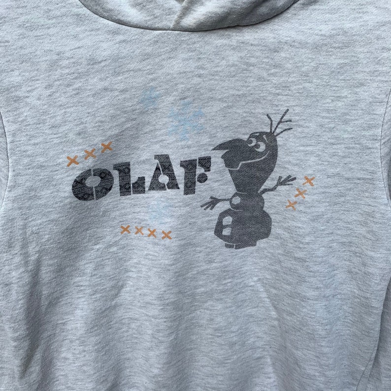 May include: Gray hooded sweatshirt with a black and white graphic of Olaf from Frozen. The graphic says "Olaf" with a series of "x" symbols around it.