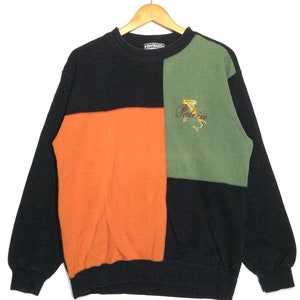 Könnte beinhalten: Ein schwarzer, orangefarbener und grüner Colorblock-Sweatshirt mit dem Wort "Palrizzo" auf der grünen Seite gestickt.