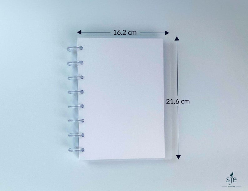 May include: A white notebook with a clear plastic spiral binding. The notebook measures 16.2 cm by 21.6 cm.