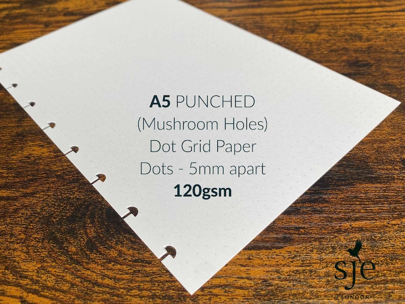Puede incluir: Un cuaderno de papel de puntos A5 con agujeros perforados. El papel es de 120 g/m&sup2; y los puntos est&aacute;n separados 5 mm. El cuaderno es blanco con una textura sutilmente moteada.