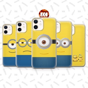 Può includere: Una collezione di custodie per telefoni gialle con disegni di personaggi dei Minion. Ogni custodia ha un volto diverso di Minion, con fondi in stile denim blu. Le custodie sono disposte in fila, mostrando la varietà di espressioni.