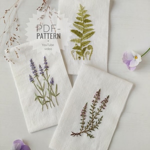 May include: Three white fabric panels with embroidered botanical designs: a fern, lavender, and heather. The embroidery uses green, purple, and brown threads. The image includes text that says "PDF Pattern + YouTube video".