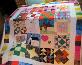 May include: A patchwork quilt with a variety of colorful squares and patterns. The quilt features a central panel with a house, a church, a heart, and a dancing couple. The quilt is made with a variety of fabrics, including floral prints, geometric patterns, and solid colors.