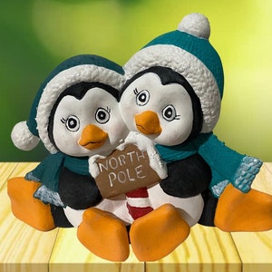 This ceramic figurine of a black and white cuddle penguins will look great in any home and nursery decor.