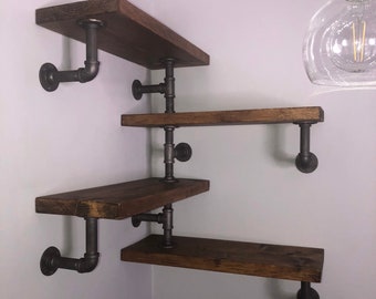May include: Four wooden shelves with black metal pipe brackets, mounted in a corner of a room. The shelves are staggered and the brackets are in a simple industrial style.