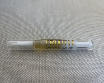 Puede incluir: Un aplicador de plástico transparente tipo bolígrafo con aceite para cutículas y uñas de color amarillo claro. La etiqueta muestra el texto dorado TROOTH seguido del texto negro CUTICLE & NAIL OIL y texto menor debajo.