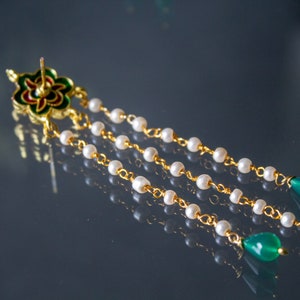 May include: Gold earrings with a green and red floral design, white pearl beads, and green gemstone drops.